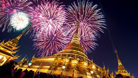 fireworks over a golden temple at night