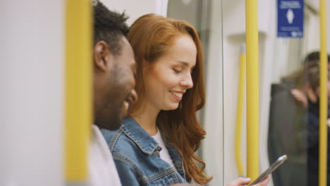 una joven pareja de vloggers o influencers sociales viajando por la ciudad en el metro para las redes sociales