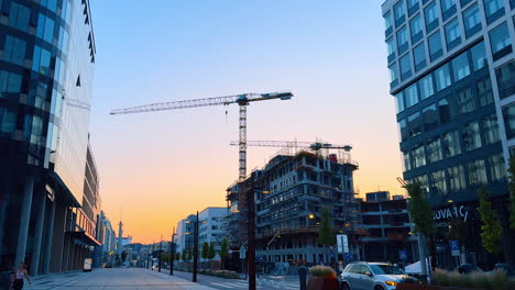 bratislava, slovakia - june 5, 2025: urban new building project. construction workers and cranes carry out work in a modern city area during sunset, creating a vibrant atmosphere