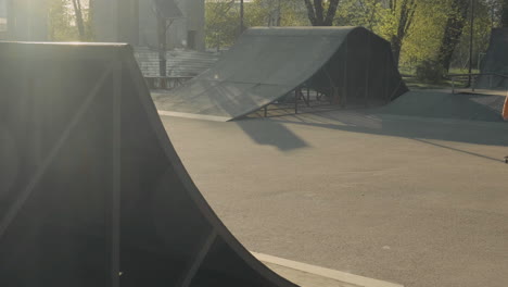 young skater girl turning on a ramp at sunset in a skate park 1