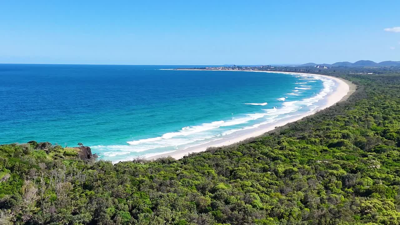 Aerial view showcasing a vibrant coastline, dense greenery, and a tranquil river curve.