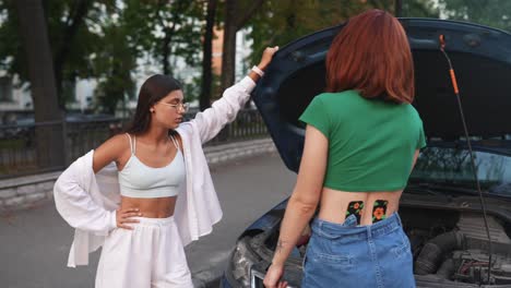 dos mujeres ayudando con un coche averiado