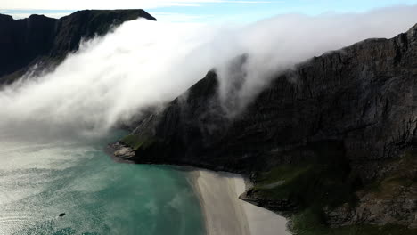 Drone-footage-of-an-epic-scene-of-clouds-pouring-over-a-ridge-in-the-background