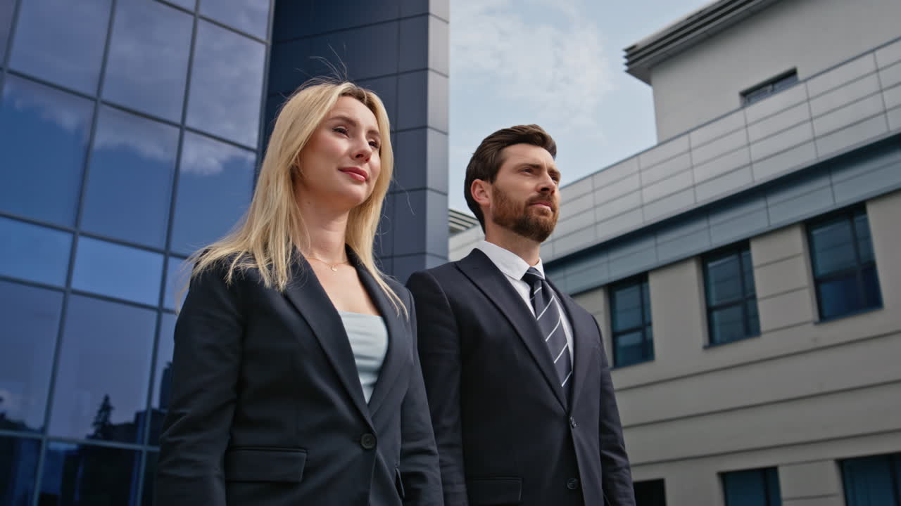 Confident business professionals standing outside corporate building closeup