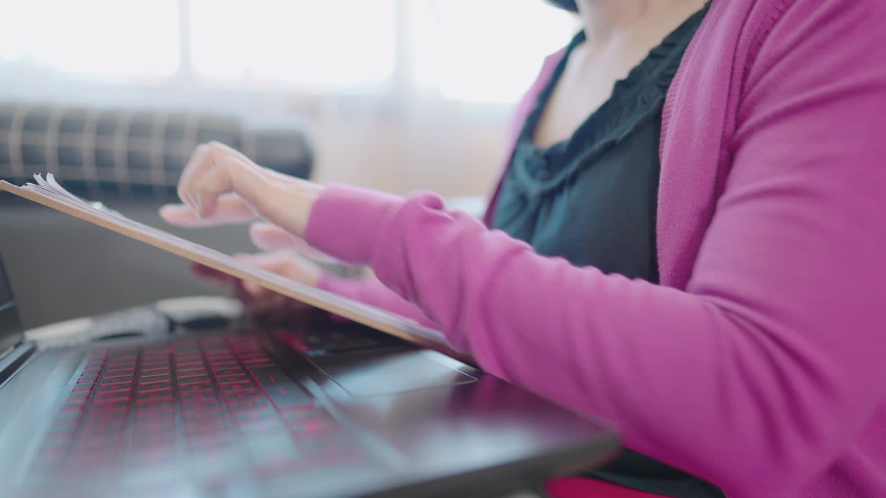 una mujer en primer plano sentada en un sofá escribiendo información en una computadora portátil para comprar en línea en casa