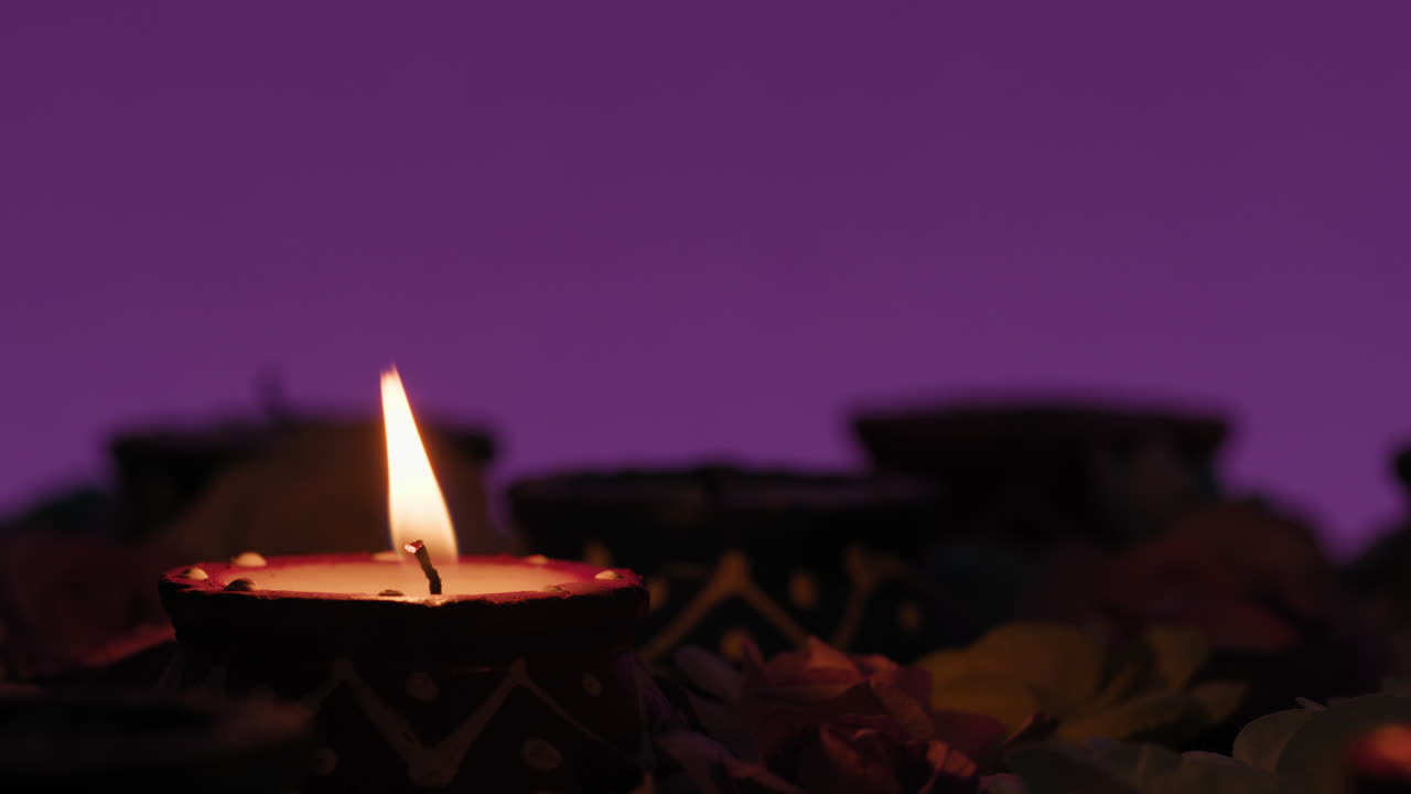 Diwali Silhouette hand lights a candle to celebrate Indian culture
