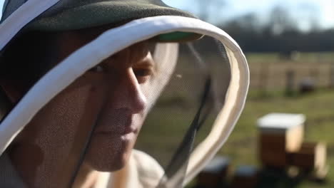 close-up of a beekeeper in a protective suit at an apiary
