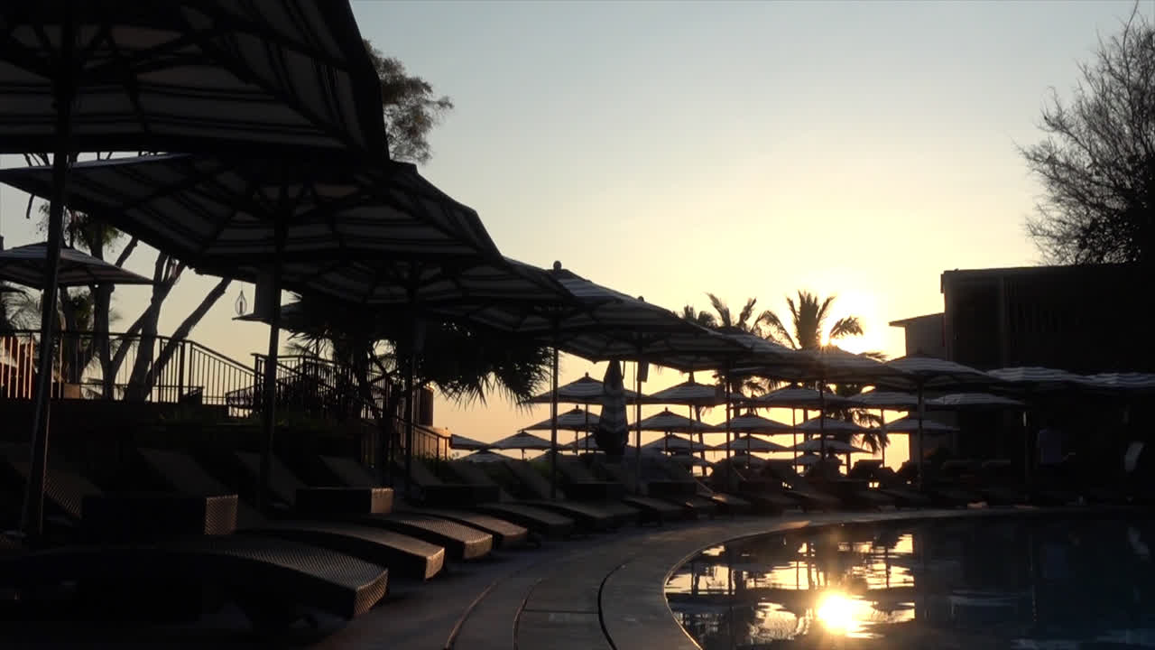 휴가 개념-4를 위한 호텔 리조트의 수영장 주변에 파라솔이 있는 침대 수영장