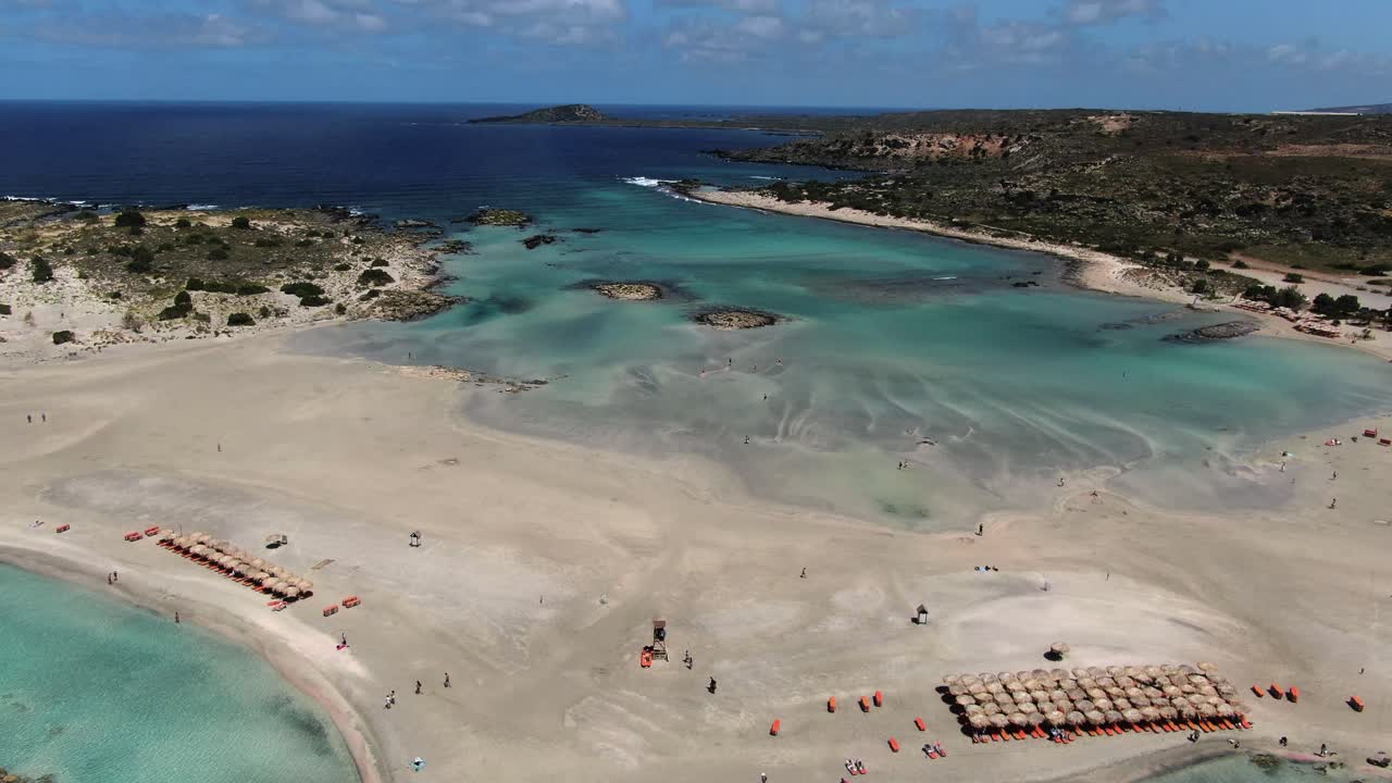 aerial over turquoise sea approaching idyllic sandbank beach in Crete