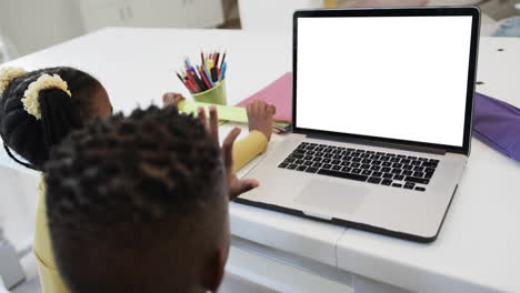 composition of african american schoolgirl and schoolboy on laptop online learning with blank screen