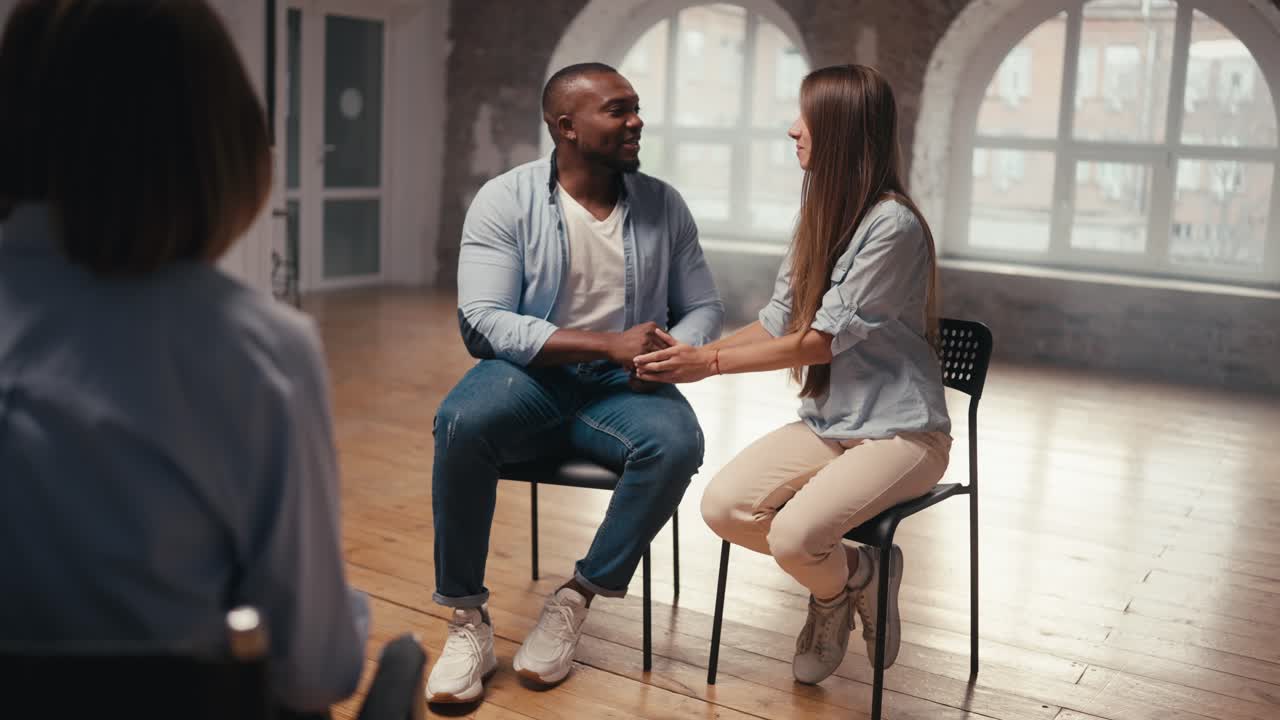 hombre feliz con color de piel negra y corte de pelo corto junto con su novia con cabello largo gracias al psicólogo para la terapia conjunta. finales felices a la terapia de grupo para parejas