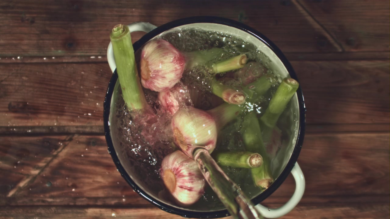 Fresh Young Garlic Being Washed in a Pot