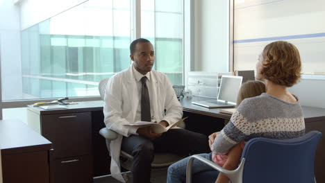 pediatrician meets with mother and daughter in hospital