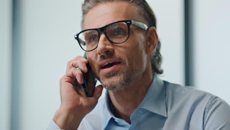 smiling businessman speaking mobile phone closeup. man talking cell emotionally