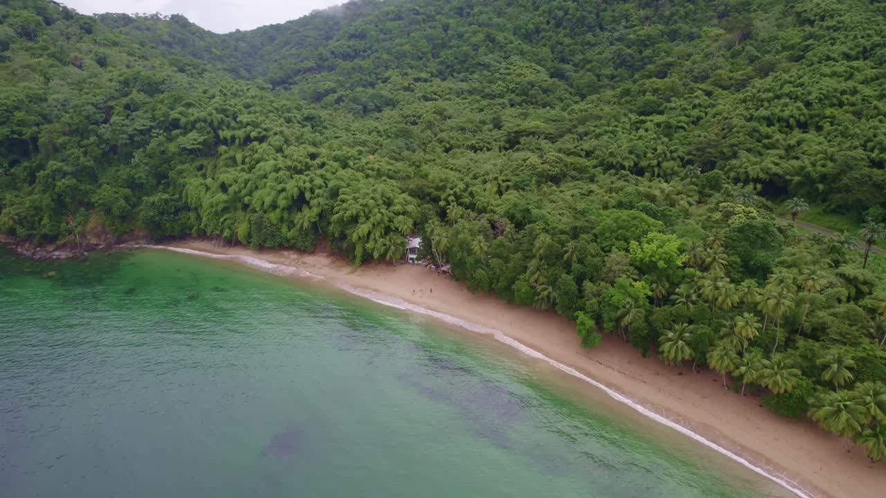 dron volando hacia una casa solitaria rodeada de agua y árboles