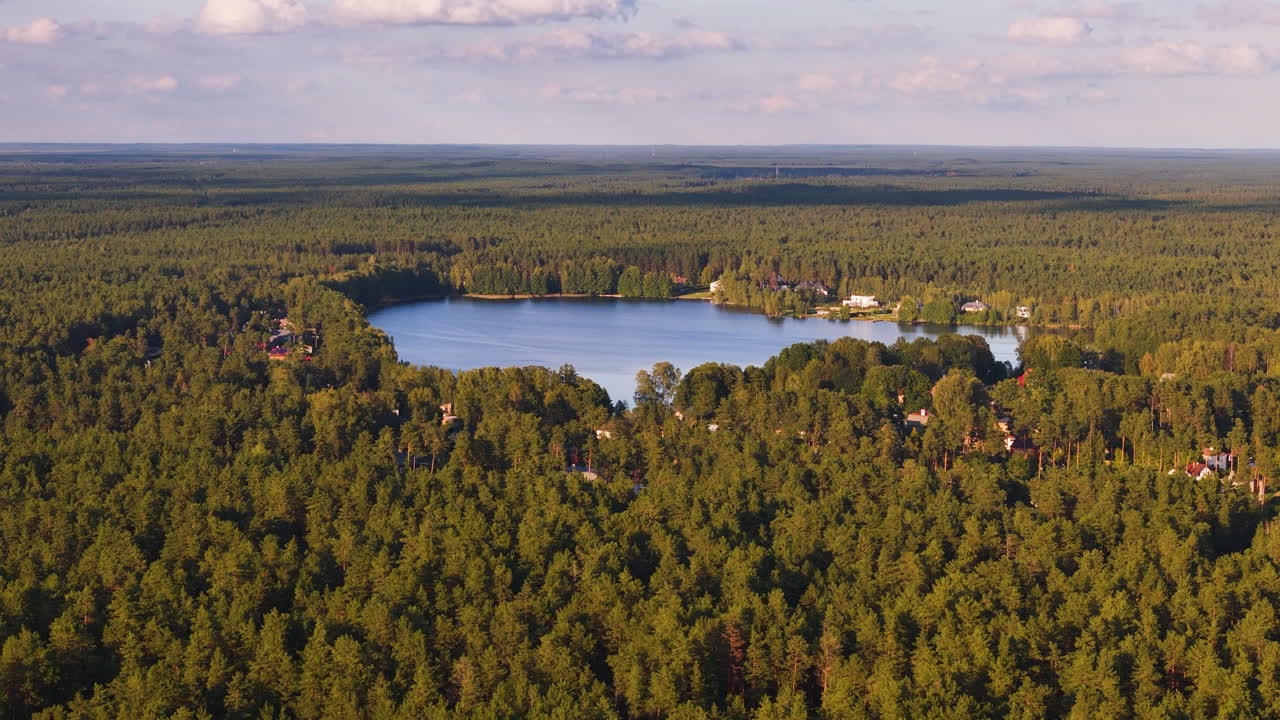 라트비아 리가 근처의 랭스티니 마을의 푸른 숲 풍경 사이에서 고립된 호수