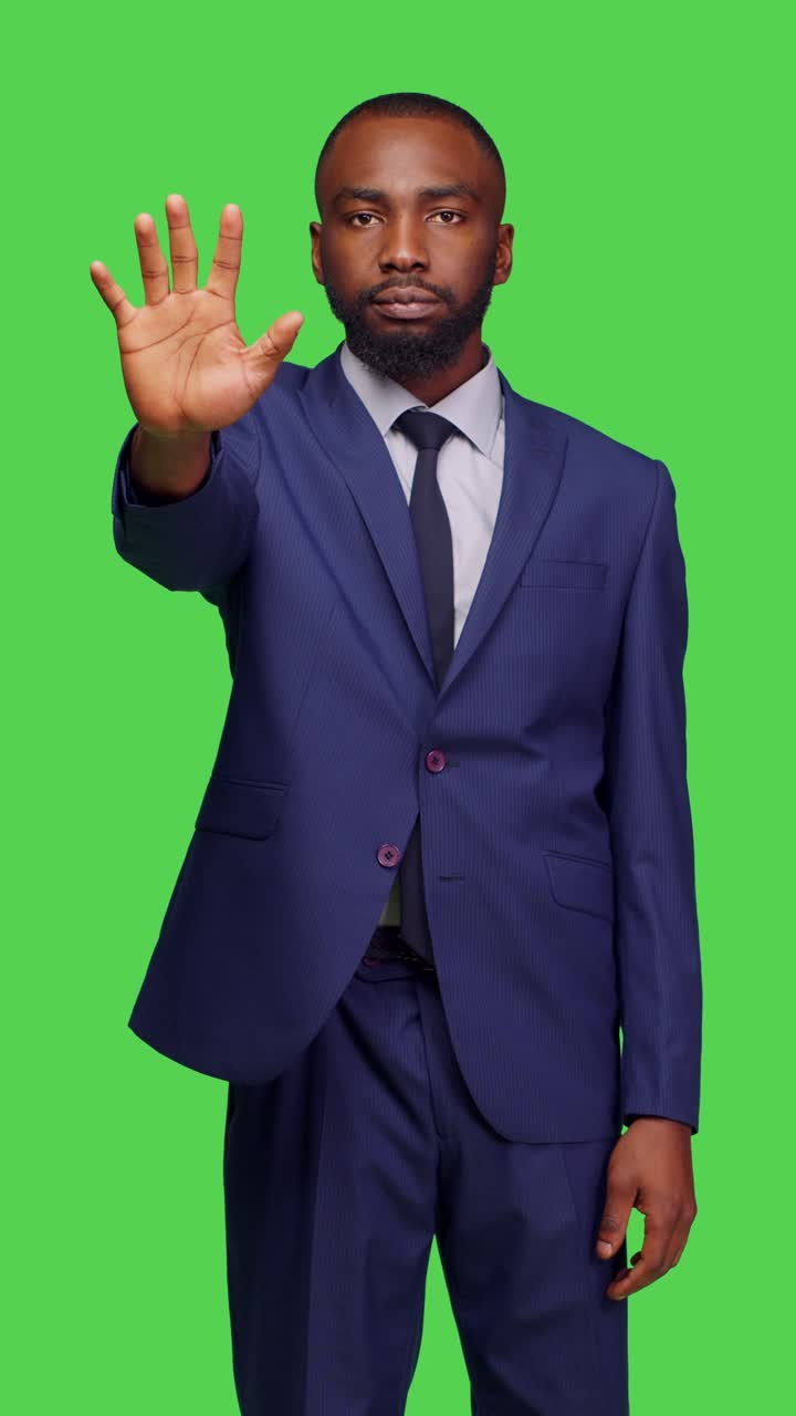 Vertical video: Front view of african american adult raising palm and saying no