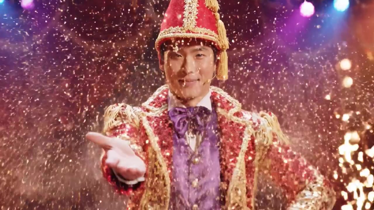 Un mago incantevole cattura il pubblico con una performance abbagliante e trucchi ipnotizzanti in un vivace ambiente carnevalesco.