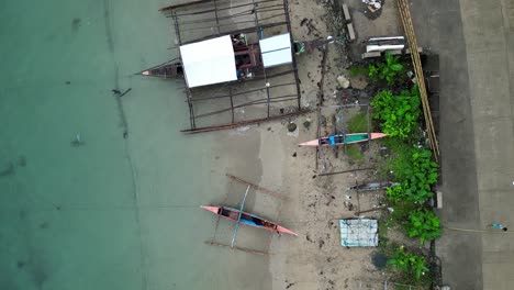 Vista-Aérea-De-Arriba-Hacia-Abajo-De-Los-Barcos-Bangka-Estacionados-En-Una-Playa-De-Arena-Blanca-Con-Aguas-Cristalinas-En-Catanduanes,-Filipinas