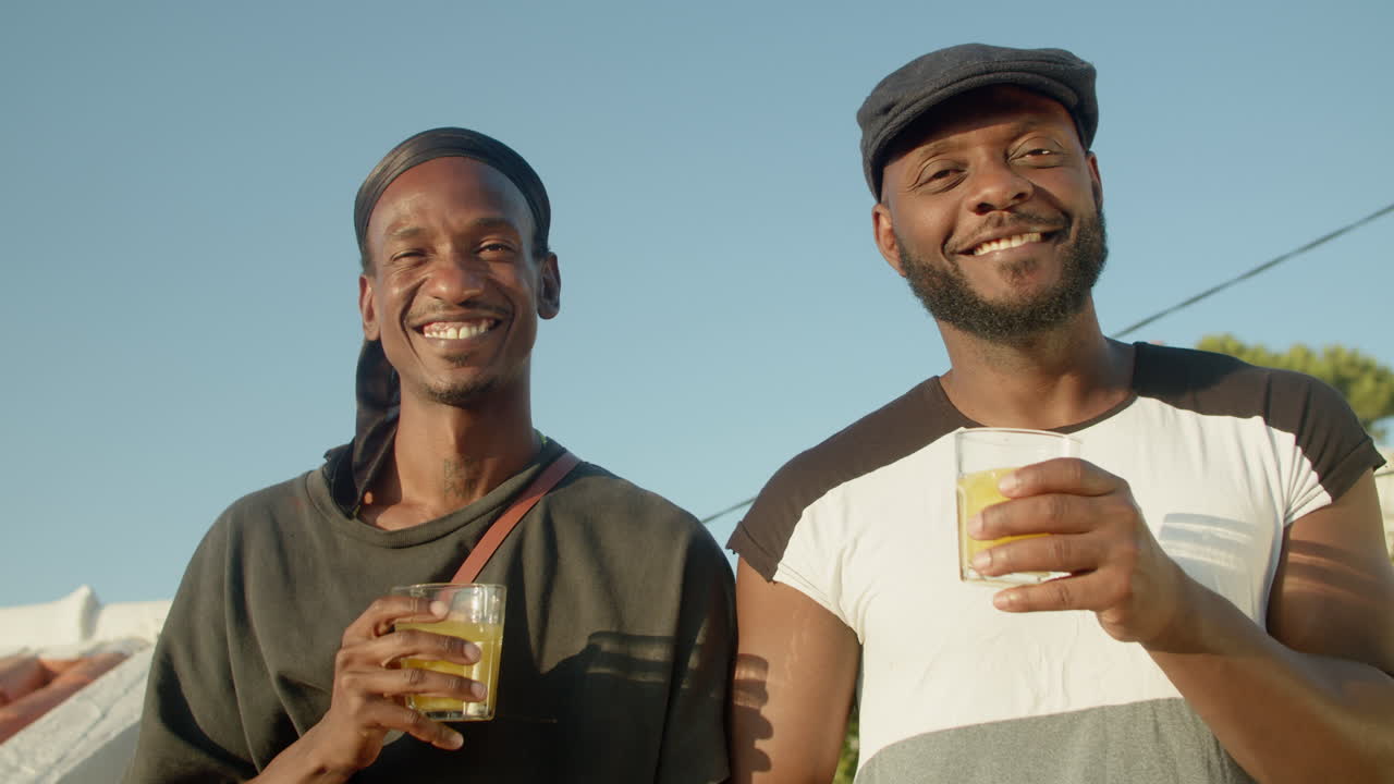 Front view of gays clinking glasses and looking at camera