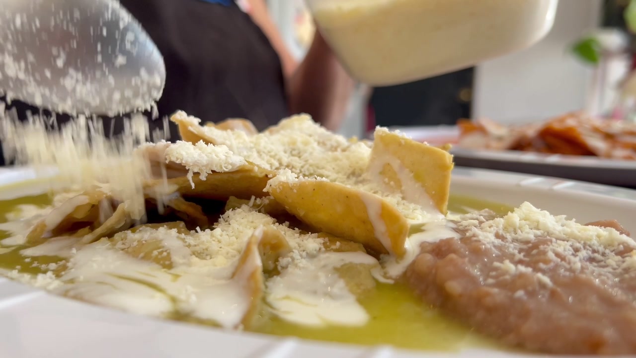 Vista dal basso di formaggio cosparso su patatine fritte fumanti con formaggio e fagioli