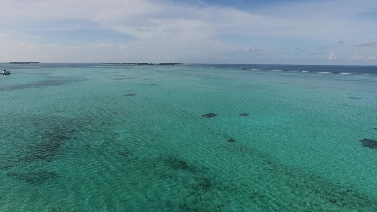toma panorámica de drones del océano índico con callejón de villas de agua en un resort de maldivas