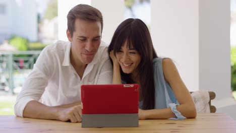 hombre y mujer saludando a su tableta