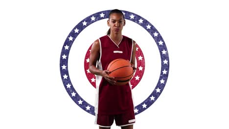 african american female basketball player holding basketball against stars on spinning circles