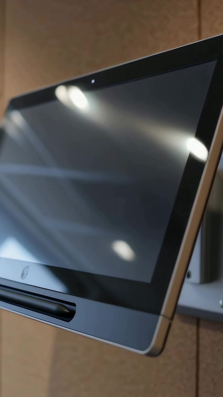 Video verticale: Telecamera in movimento che rivela un tablet a parete più da vicino su una parete beige per mostrare i riflessi dello schermo.