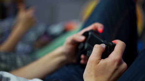 Close Up view of woman&#039;s hands playing video game at home. Shooting and controlling using the game controller. Wireless game