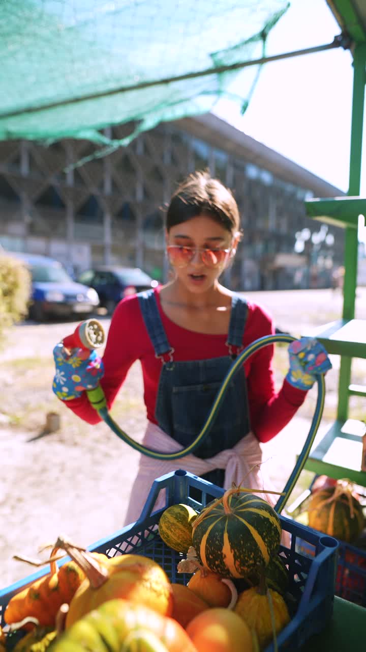 niña comprando calabazas en un mercado al aire libre