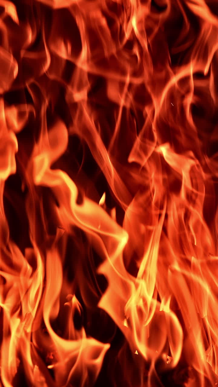 Campfire flame glowing on dark background. A fire pit with burning flame.