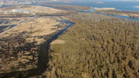 Panning-drone-shot-of-a-forest,-rivers-and-flooded,-excavated-areas