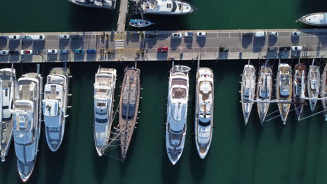 Yates-De-Lujo-Y-Veleros-Atracados-En-El-Puerto-Deportivo-Con-Coches-Aparcados-En-Palma-De-Mallorca,-España