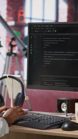 vertical video developer at computer desk coding while listening music