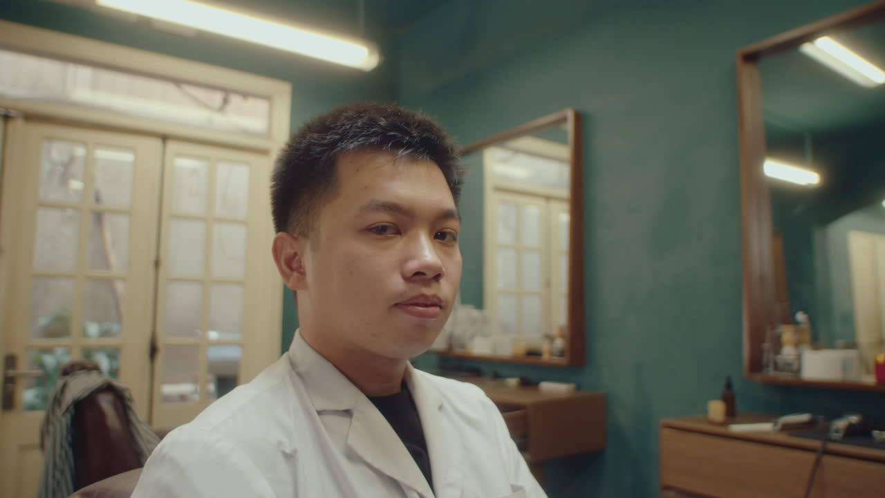 Young Asian Barber at Work in Retro Styled Hairdressing Salon