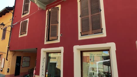 red facade with windows and balcony in barolo