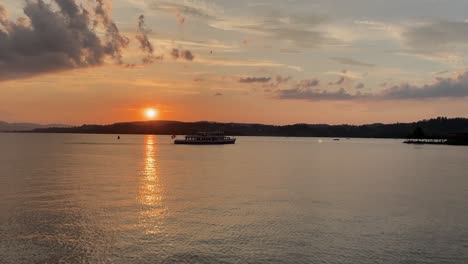 Golden-hour-sunset-over-lake-Zurich-harbor-with-ship-in-water,-Switzerland