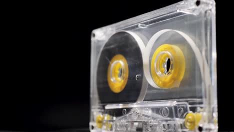 Rotating-yellow-transparent-audio-cassette-on-a-black-background