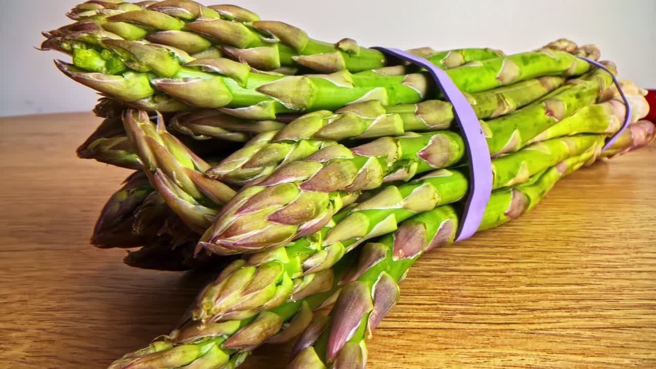 Fresh asparagus bundle on wooden table evokes health and freshness