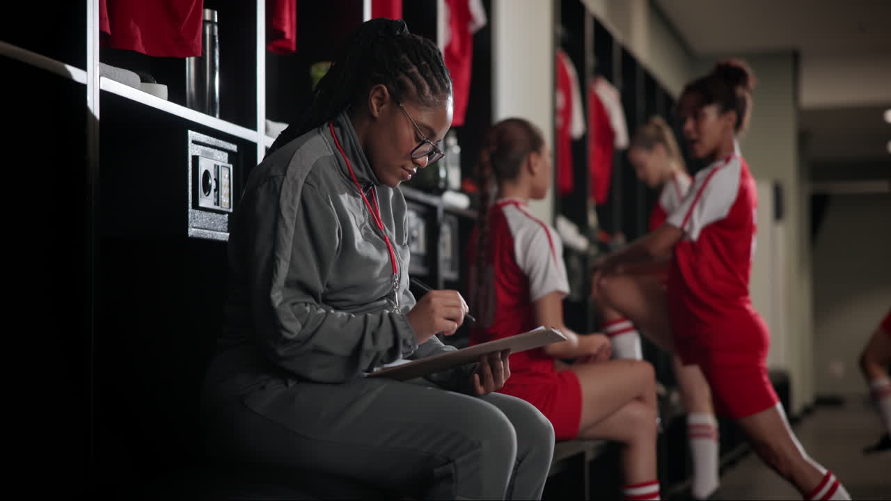 Soccer team coach reviewing notes in the locker room