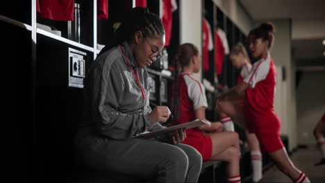 soccer team coach reviewing notes in the locker room