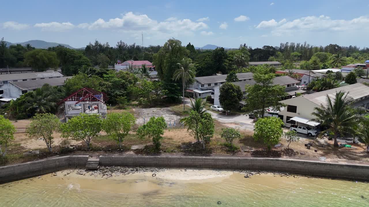 las imágenes de drones capturan la serena costa de phuket y la exuberante vegetación bajo la luz del día, mostrando aguas tranquilas y paisajes vibrantes.