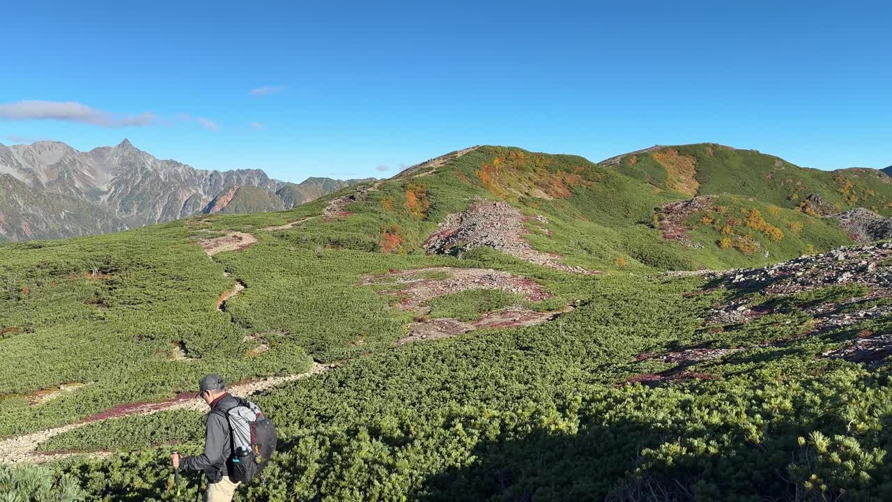 Breathtaking panoramic view of the Hotaka Mountain Range on a clear autumn day. Experience the vibrant fall colors and rugged terrain of the Panorama Ginza trail in Japan's Nagano region