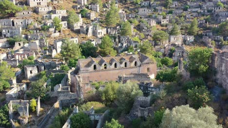 drone aéreo dando vueltas sobre una iglesia ortodoxa griega abandonada en el pueblo fantasma de kayakoy en fethiye turquía en un día soleado de verano