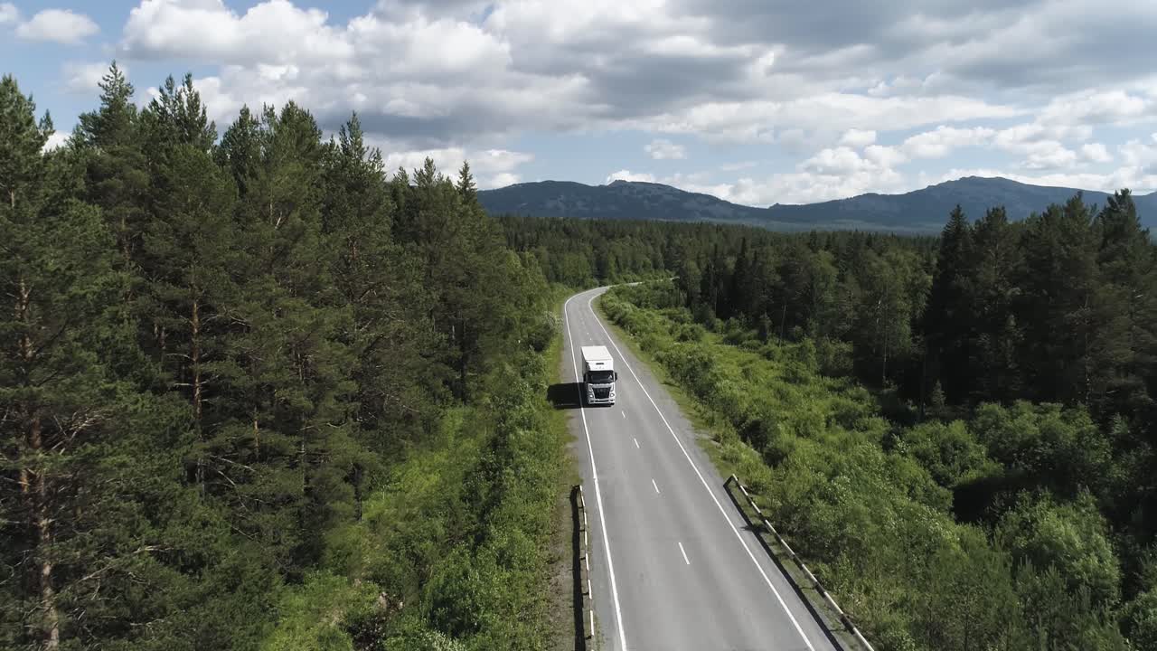 Lastbil på en naturskøn bjergvej gennem en skov