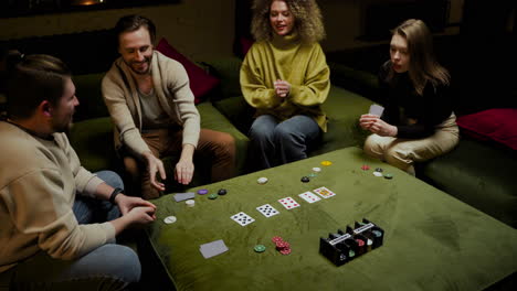 blick von oben auf eine gruppe von freunden, die poker spielen und auf der couch im wohnzimmer sitzen