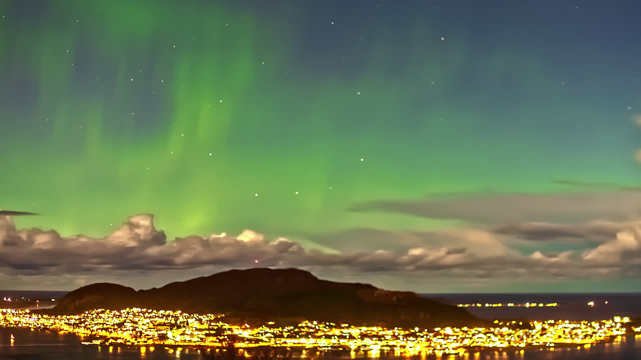 majestuosas luces del norte sobre la ciudad brillante, vista en lapso de tiempo