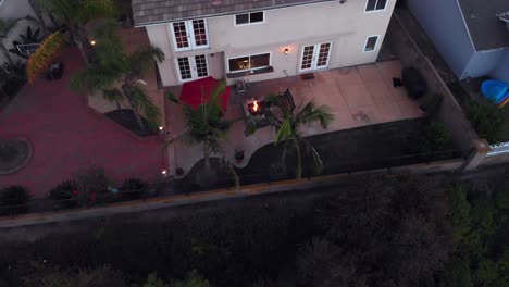 aerial rotation at twilight over a suburban house backyard with the fire pit on