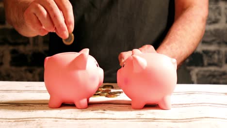 Unequal, unfair distribution of funds between two piggy banks by male hand, Euro coins on table